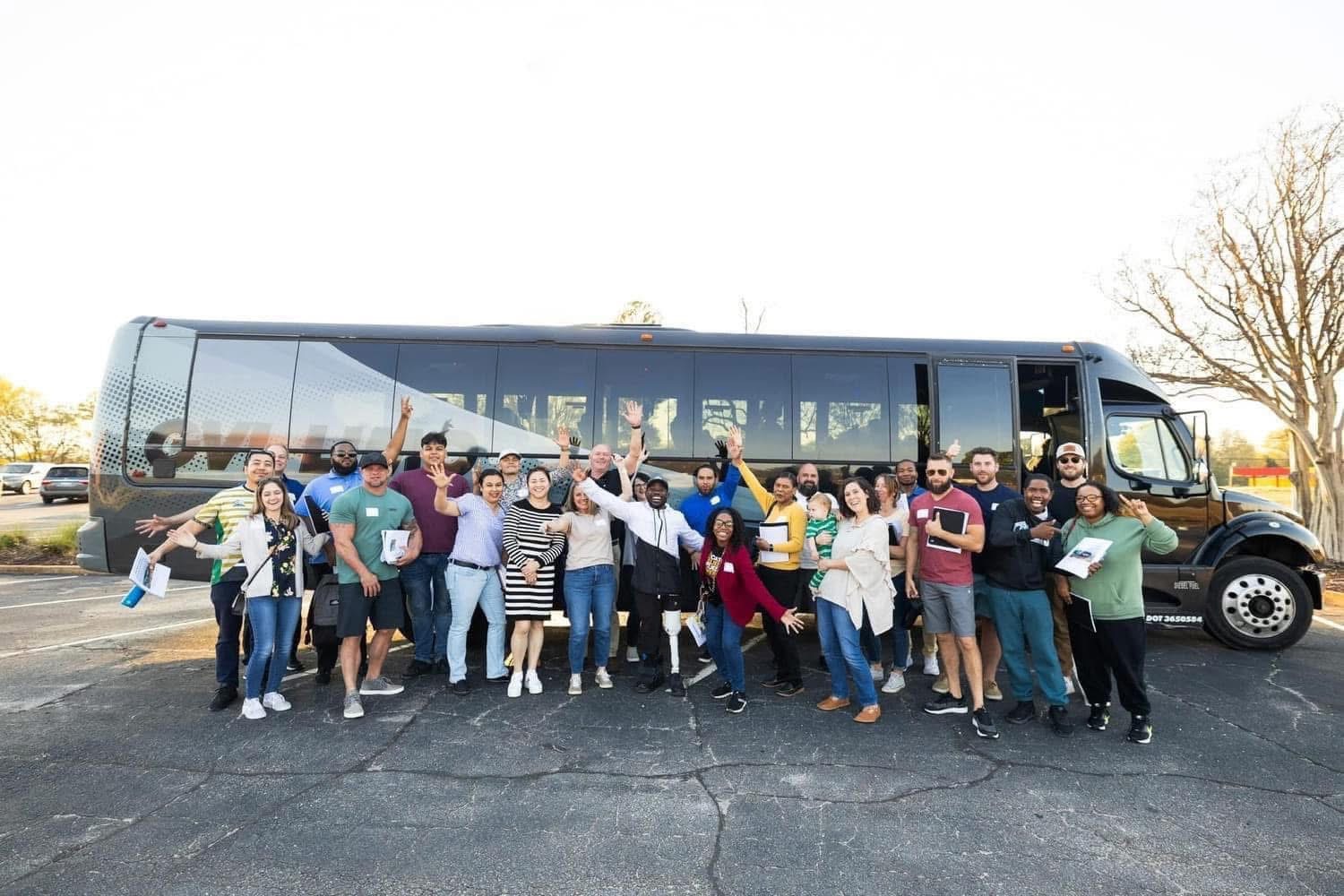 Myles with a large group of students on a bus tour